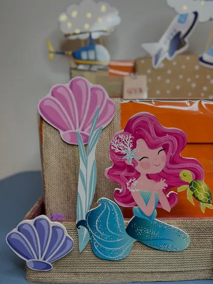 On the other side of the hamper, this close-up shows the mermaid and seashell cutouts for Aadiya Shakti, creating a beautiful 'under the sea' theme.