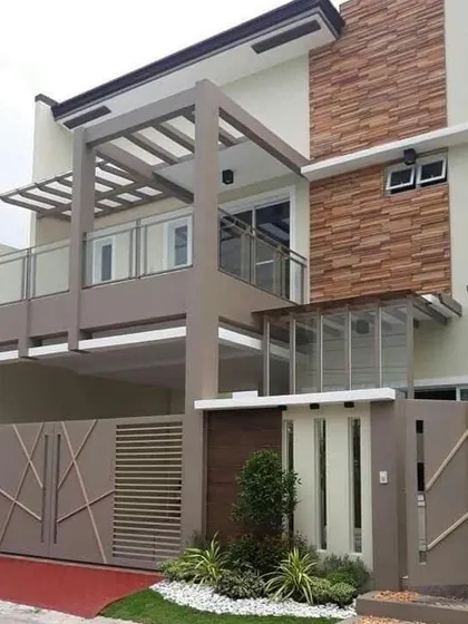A duplicate of a previous design, this home uses a neutral color palette with stone cladding for a timeless look. The structure incorporates a second-floor balcony and a glass-enclosed section, balancing open and private spaces.