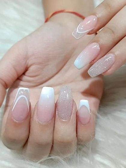A mixed-style set featuring a combination of French tips, ombre fades, and a full glitter accent nail, all in a cohesive white and nude palette.