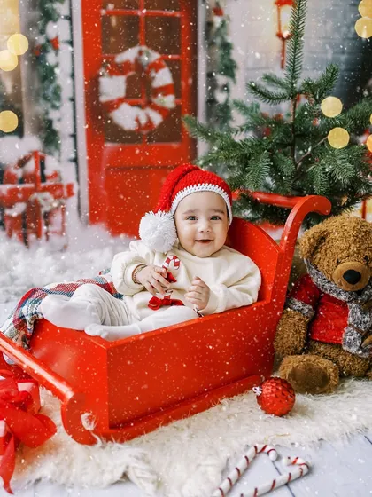Another joyful shot from this Christmas session, with snow falling around the happy baby in her sleigh.