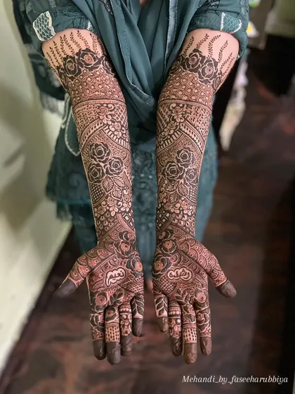 The completed bridal henna for Rushda, showcasing a symmetrical design rich with roses and delicate patterns.