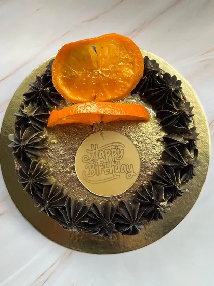 A simple yet elegant design for our Drunken Zesty Belgian Chocolate cake, topped with candied orange slices and a "Happy Birthday" plaque.
