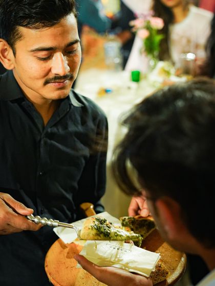 A guest being served a slice of our fresh basil pesto pizza at a polo match. Our live pizza station is always a popular feature at outdoor events.