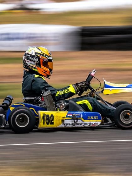 A driver navigates a corner with precision. Mastering the racing line is a key skill we develop through expert coaching and data analysis.