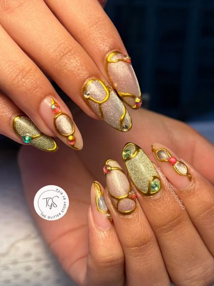 An ornate and luxurious design featuring sculpted gold lines over a shimmery cat-eye base. The look is completed with carefully placed colorful gems for a jewelry-like effect.