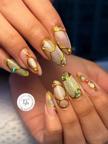 An ornate and luxurious design featuring sculpted gold lines over a shimmery cat-eye base. The look is completed with carefully placed colorful gems for a jewelry-like effect.