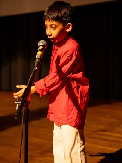 A young boy delivering his lines with earnest expression. This solo moment highlights the individual confidence that each child builds.