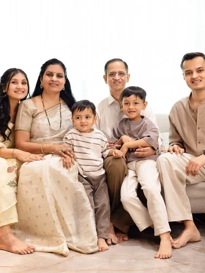 A formal extended family portrait with grandparents, parents, and children, all dressed in beautiful neutral tones.