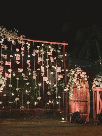 A personalized photo memory wall for the couple. I hung their pictures on strings with fairy lights and white roses, creating a heartfelt and beautiful installation for the reception.