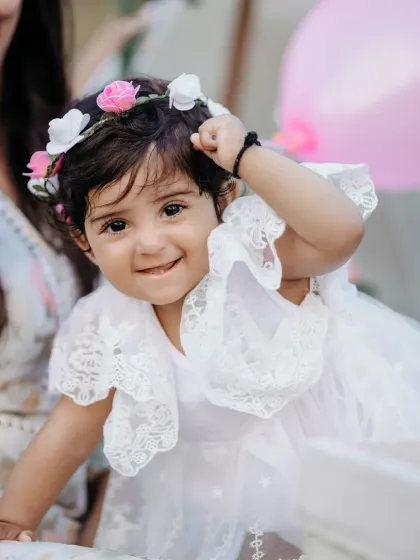The pure, unfiltered joy of childhood. This close up portrait of a little girl in her lace dress and flower crown captures her playful spirit and sweet innocence during a family photography session.
