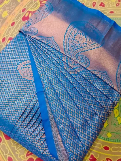 A blue silk saree with silver brocade, with pleat sizes customized for the client.