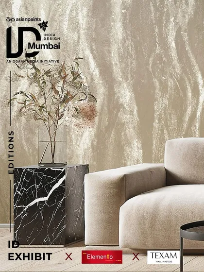 A promotional image for our exhibit at India Design, showcasing a luxurious textured wallpaper with a subtle wave pattern. Paired with a marble side table and a minimalist sofa, it highlights our focus on sophisticated, textural backdrops.