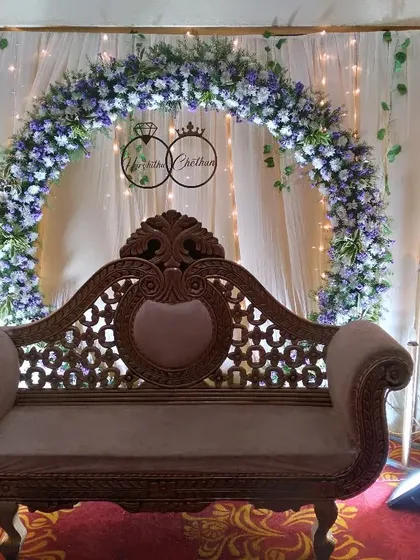 This is a classic and elegant engagement stage I designed. It features a full floral arch of blue and white hydrangeas against a soft curtain backdrop, with vintage-style lighting to create a romantic ambiance.