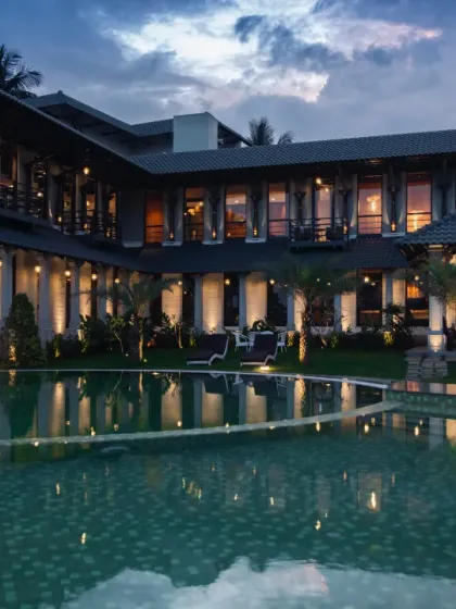 An exquisite interplay of form and reflection, where architectural finesse meets the tranquil embrace of water. This farmhouse, poised with timeless elegance, finds its perfect mirror in the shimmering pool, creating a vision of harmony and refinement at dusk.