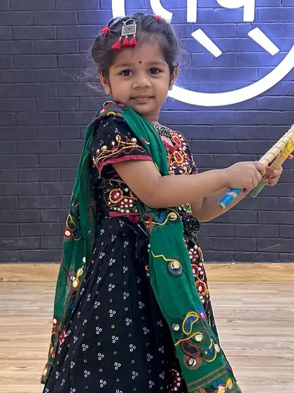A close-up of one of my littlest dancers in her Garba outfit, holding a dandiya stick. She looks absolutely adorable.