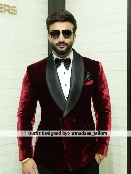 The epitome of classic luxury. Our client wears a bespoke double-breasted tuxedo crafted from rich maroon velvet with a contrasting black satin shawl lapel, perfect for any black-tie affair or cocktail evening.