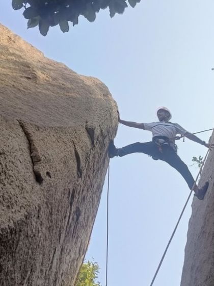 Rahul executing a wide stem move between two boulders. His story is about embracing new challenges and the joy of accomplishment.