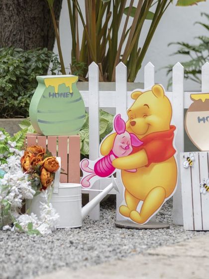 More cute props from the Pooh party, including honey pot cutouts and a white picket fence to create a lovely garden feel.