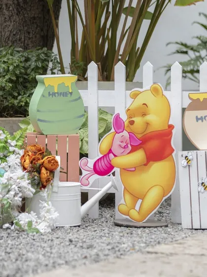 More cute props from the Pooh party, including honey pot cutouts and a white picket fence to create a lovely garden feel.