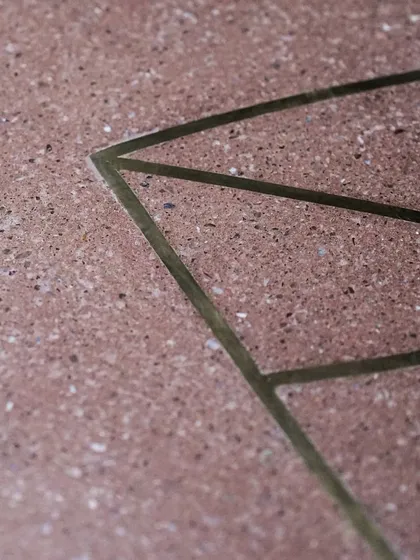 A close-up of the brass inlay on our custom leaf table. Every line is carefully placed to create a design that is both intricate and minimalist, adding a touch of sophistication to the earthy terrazzo.