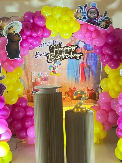 A bright and cheerful Masha and the Bear themed second birthday. The setup is filled with pink and yellow balloons and features cutouts of the beloved characters.