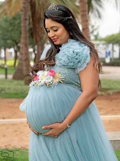 A stunning solo portrait of the mama-to-be, her tiara making her look like a princess in an enchanted garden.