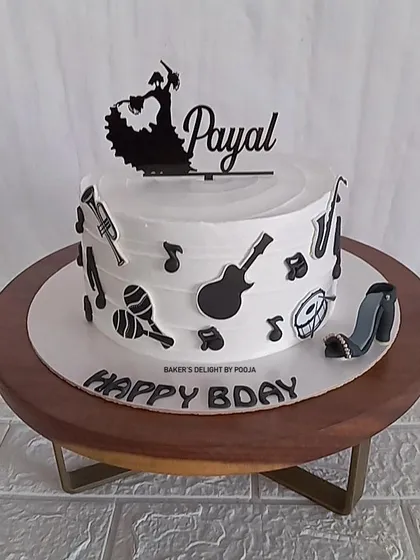 A cake for a dancer and music lover, this black and white design features a flamenco dancer topper and various musical instruments.