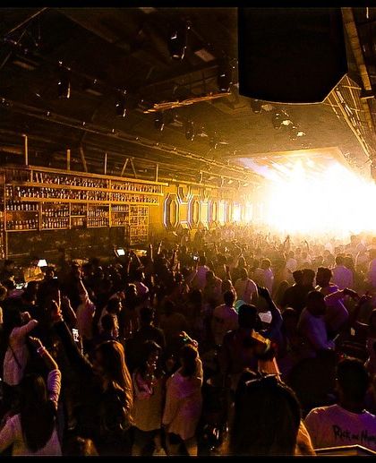 A wide shot of a packed venue, with the light exploding from the stage. This shows the scale of the parties I play, where the entire room becomes one massive dance floor.