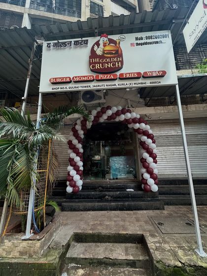 A clear, straight-on view of the maroon and white balloon arch, showcasing how it enhances the storefront for a business launch.