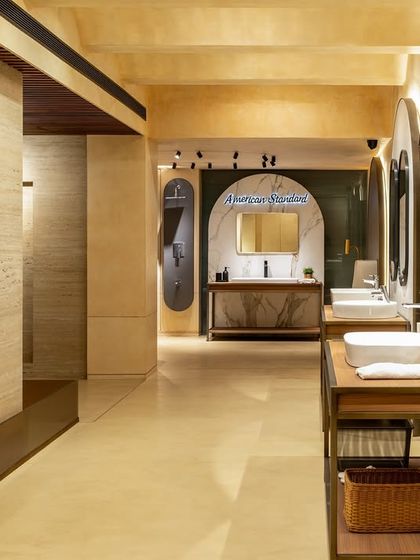 The layout of the ABC Emporio showroom uses varied vanity displays to showcase different styles. The mix of materials like stone, wood, and patinated metal creates a rich, tactile environment for customers.