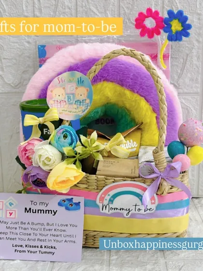 A complete view of the rainbow-themed baby shower basket, featuring a sweet "To my Mummy" card. This hamper is filled with colorful flowers, a soft cushion, and various treats to pamper the expectant mother.