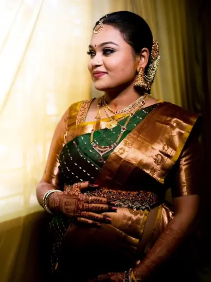 A glowing portrait of Kruthika by the window. The soft light beautifully highlights her radiant skin and the traditional makeup look we created for her baby shower.