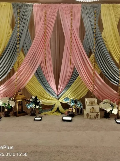 A pastel-themed Haldi decoration concept using drapes in peach, yellow, pink, and grey. This is a modern take on Haldi decor, moving away from the traditional all-yellow look.