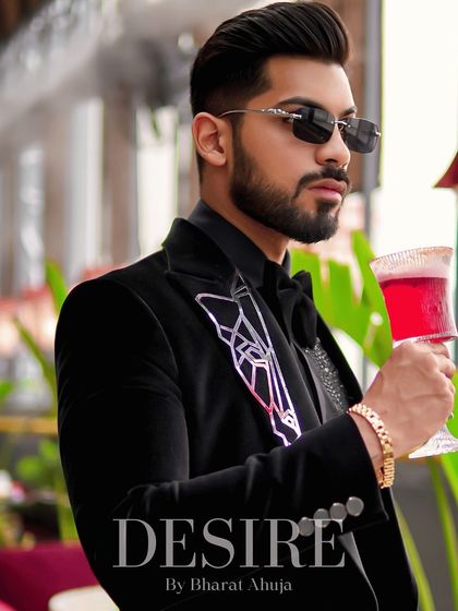 A profile view of the black velvet blazer, highlighting the sleek silhouette and the striking contrast of the white embroidery.