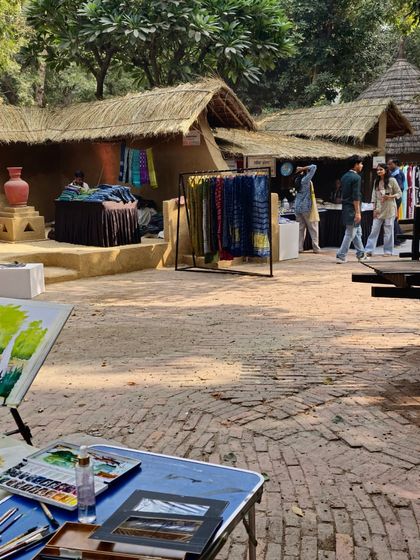 A plein air painter's setup, with an easel and palette ready to capture the rustic charm of the Craft Museum.