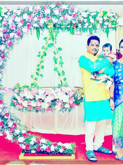 A happy family posing in front of our floral crescent moon cradle during their baby's naming ceremony. We love capturing these joyful moments.