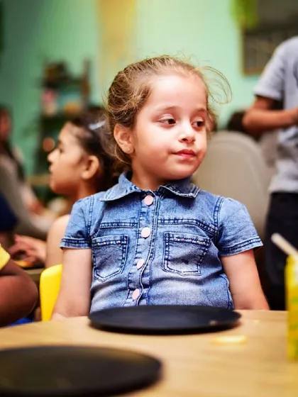 Where is my slice? A little girl waiting patiently for her party food.