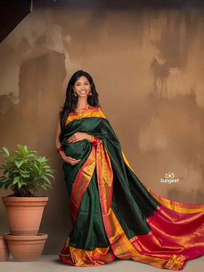 A simple and elegant standing pose that beautifully showcases the flow and color of the traditional Indian saree during a pregnancy photoshoot.