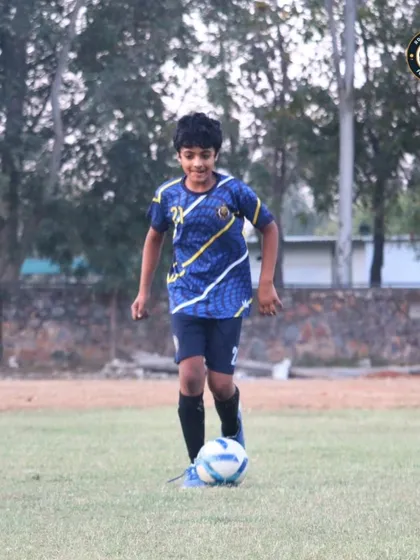 A young player confidently dribbling the ball during a training session. Our goal is to make every player comfortable and creative with the ball at their feet.