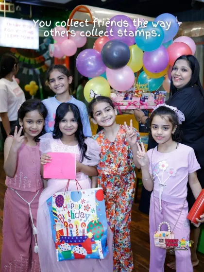 The birthday girl and her friends posing with gifts at the butterfly-themed party. It's all about creating happy memories with friends.