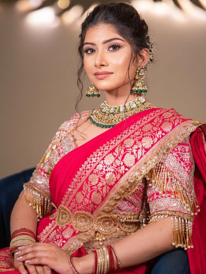 A portrait of grace and power. The soft yet defined makeup enhances her features, while the traditional saree and jewelry create an unforgettable and royal bridal statement.
