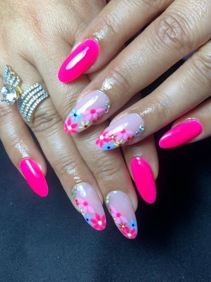 A vibrant set with bright pink nails and accent nails featuring a delicate, multi-colored floral painting.