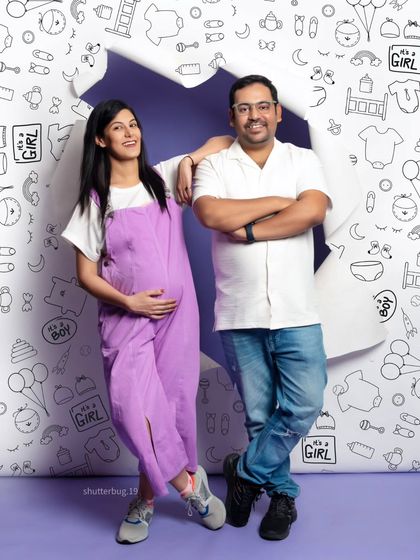 A relaxed and happy portrait of the couple with our creative doodle backdrop. The mom-to-be leans on her partner, both smiling, perfectly capturing their easygoing connection.