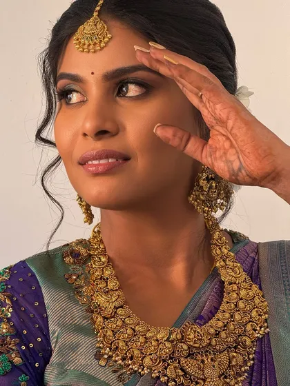 A close-up, artistic shot of Abi, highlighting her bold makeup and the intricate details of the antique necklace.