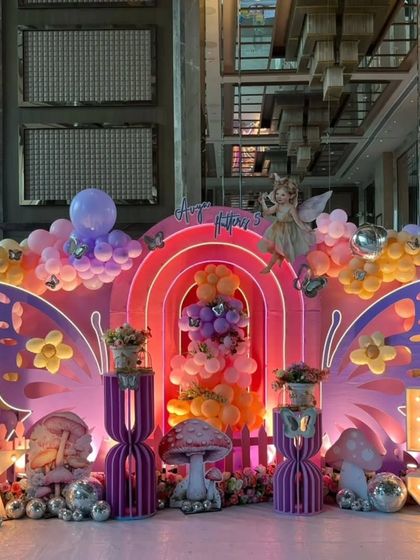 A wide shot of the stunning fairy-themed birthday stage, glowing with pink and purple lights.