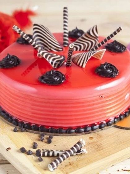 A vibrant and flavourful strawberry cake with a glossy red glaze. This cake is decorated with modern chocolate swirls and offers a fresh, fruity taste that's both refreshing and indulgent.