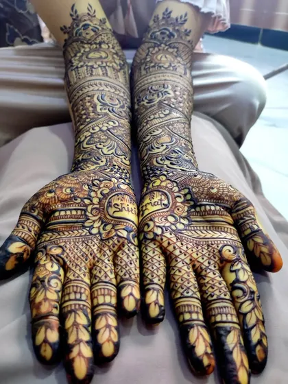 The full view of this personalized bridal henna, with the couple's names taking center stage on the palms.