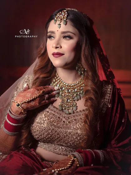 A classic and elegant bridal portrait, with the bride looking away, showcasing her profile and the stunning details of her attire.