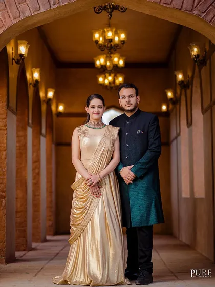 In a corridor lit by ornate lamps, Dheeraj and Navdeep look like royalty. The warm lighting and repeating arches create a stunning and symmetrical composition for this elegant couple portrait.