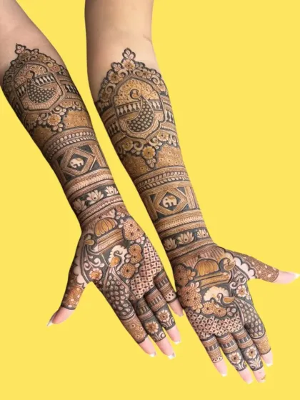 This design showcases a beautiful blend of peacock and elephant motifs, extending all the way up the arm for a full bridal look.